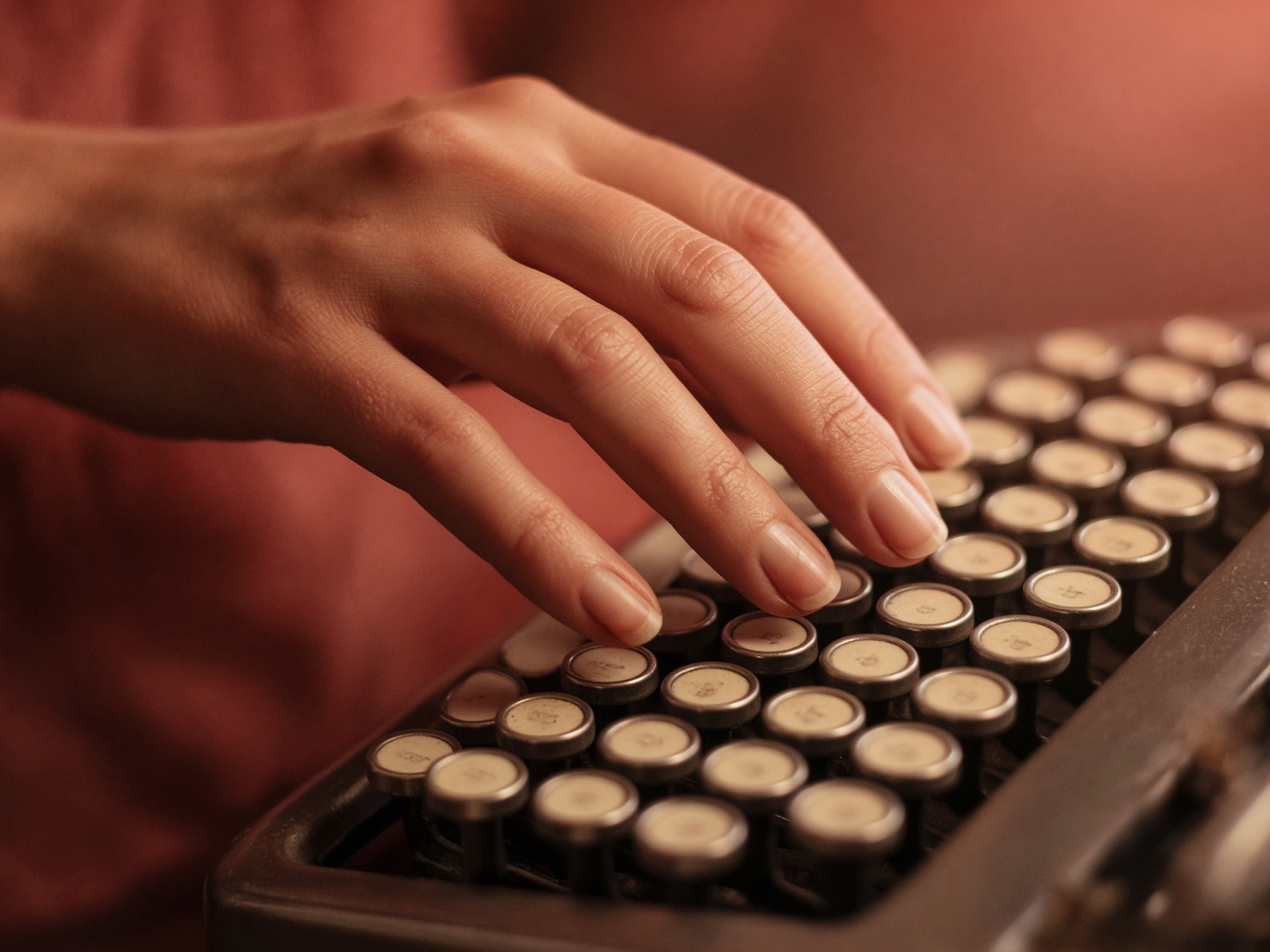 Main tapant sur un clavier, lumière intérieure chaude.